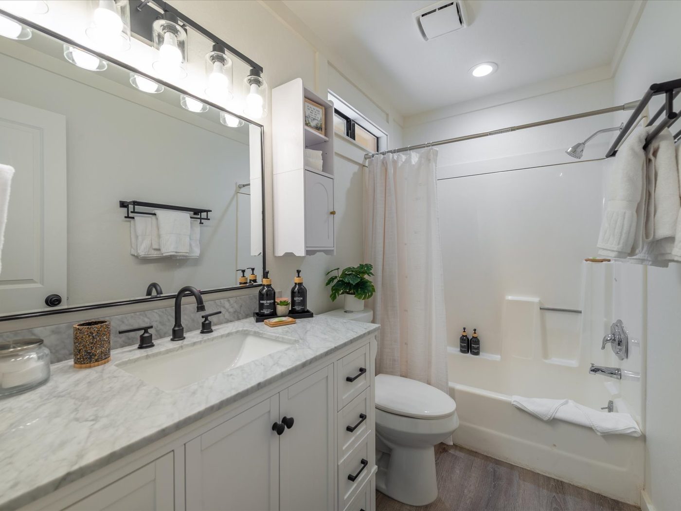 Updated full bathroom with marble vanity and tub-shower